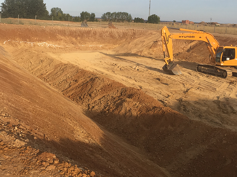 Excavadora haciendo el vaciado de terreno para la modernización de sistemas de riego.